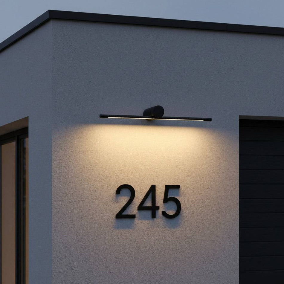 black over sign light shining down to illuminate a house number 