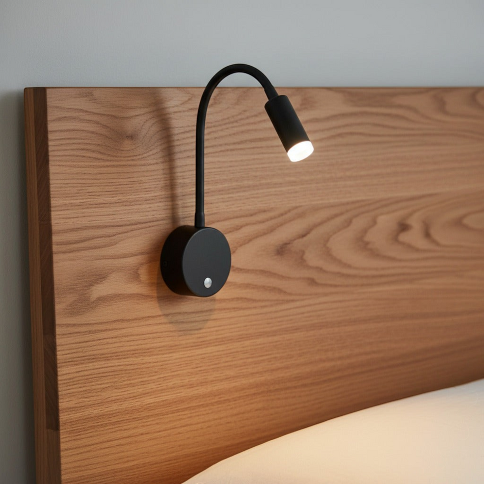 black dimmable reading light for bed mounted on a wooden bed headboard