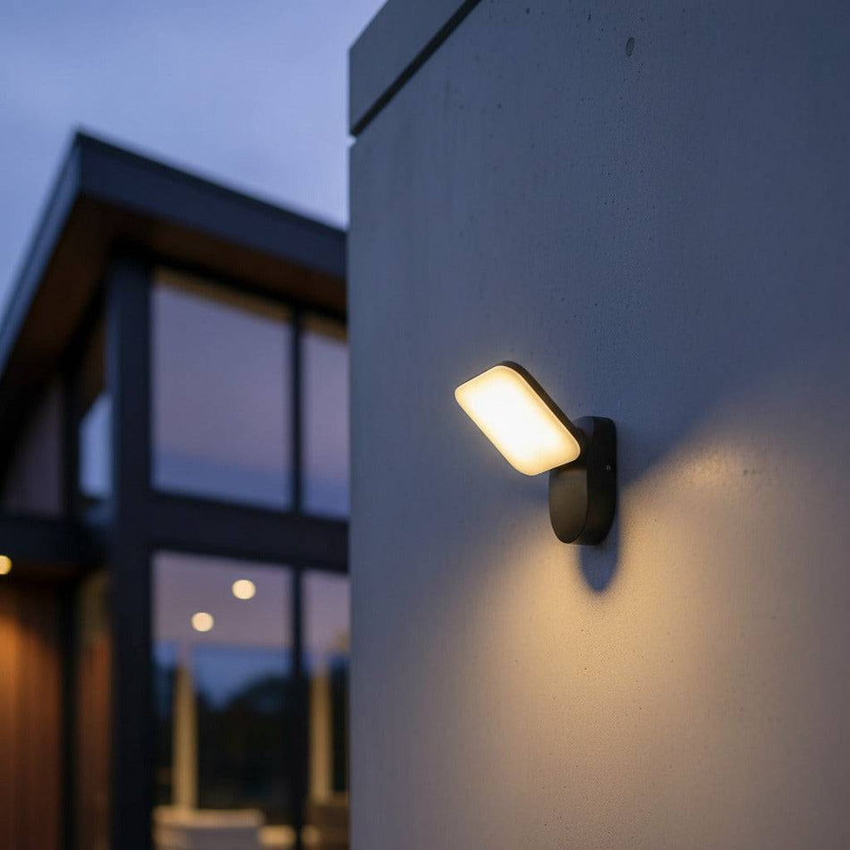 black external wall lamp mounted on a white wall outside of a modern home 