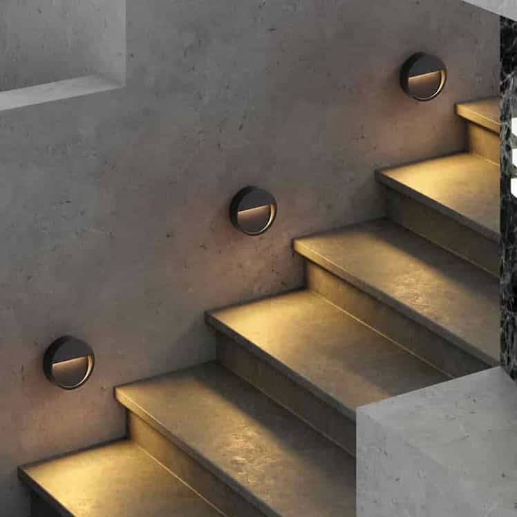 black external step light installed alongside concrete steps on the wall 