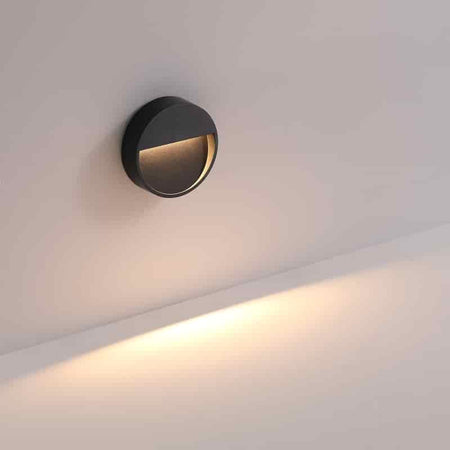 black external step light mounted on a white wall 