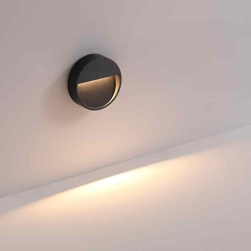 black external step light mounted on a white wall 