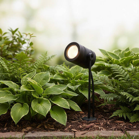 black outdoor stake light mounted in a garden border 
