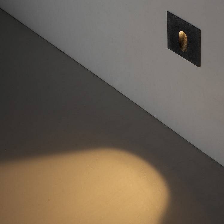 outdoor step light fixture mounted on a white wall at low level