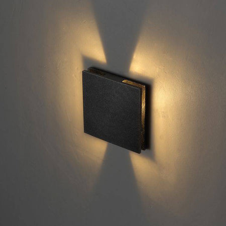 black outdoor step light mounted on a white wall 