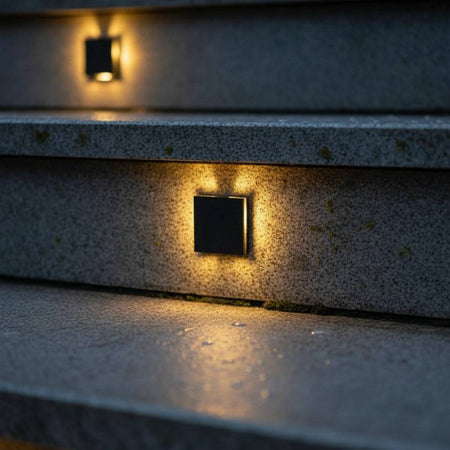 black outdoor step light mounted in the stair riser of concrete outdoor steps