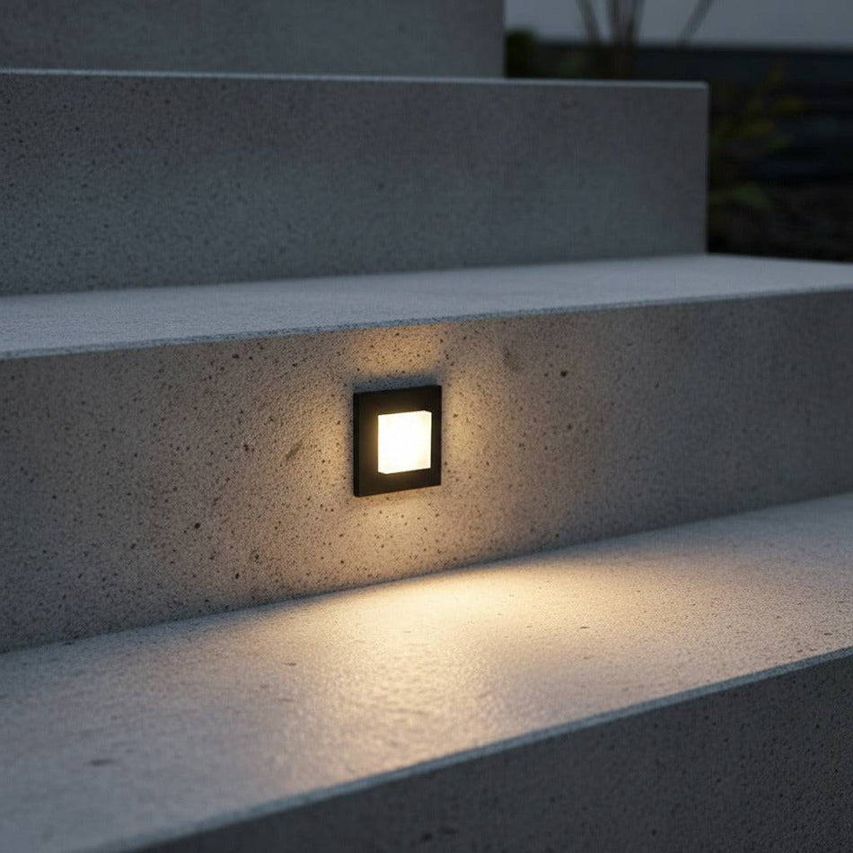 black low level recessed wall light mounted in the stair riser of an outdoor concrete staircase