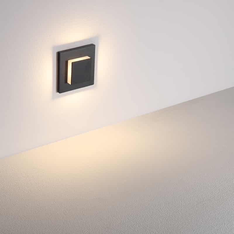 black flush outdoor wall light shown mounted on a white wall 