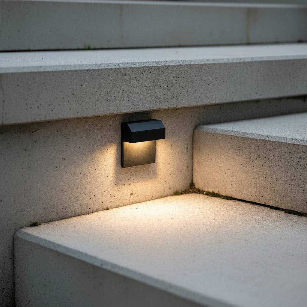 black light for outdoor stairs mounted on a concrete wall next to a step 