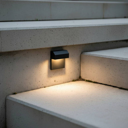 black light for outdoor stairs mounted on a concrete wall next to a step 