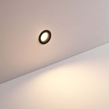 3 watt round black inset garden wall light mounted on a white wall