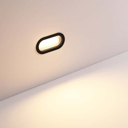 6 watt oval black recessed exterior wall light installed on a white wall