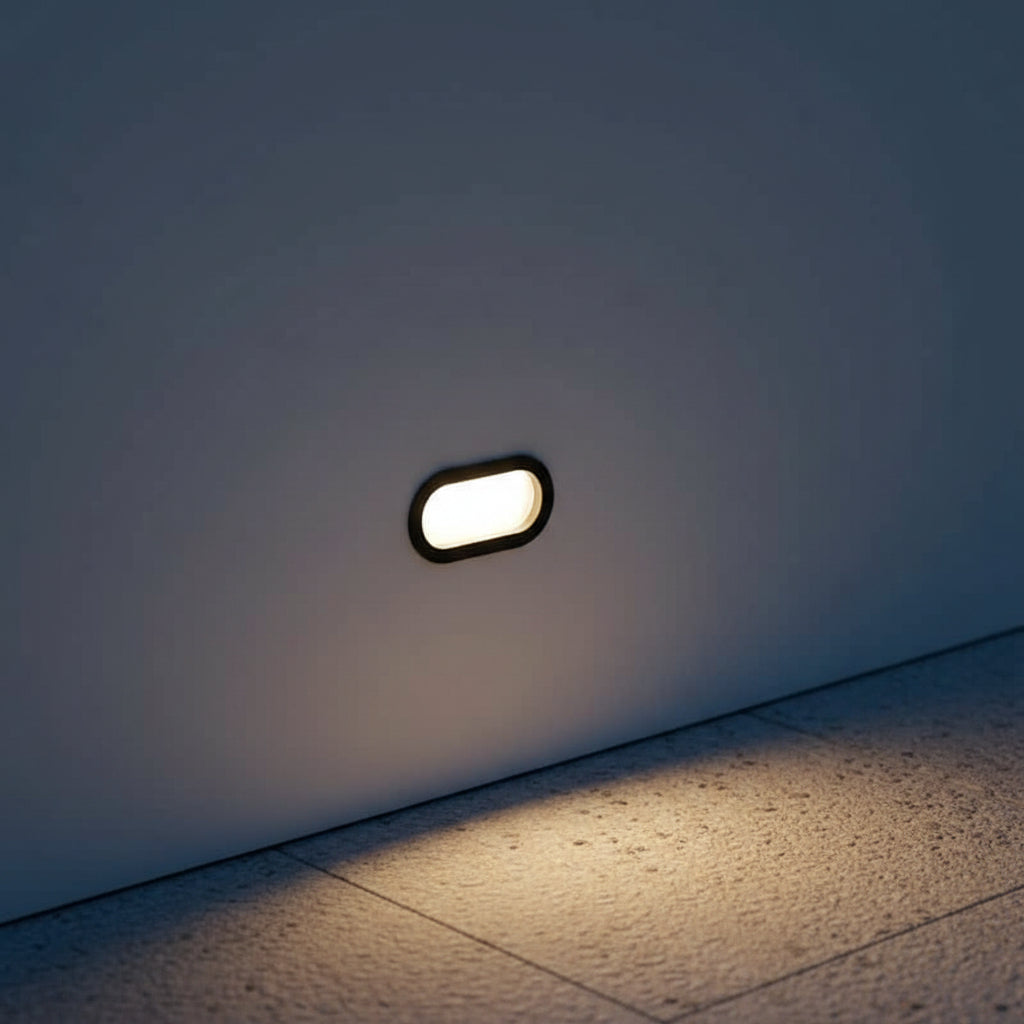 6 watt oval black recessed exterior wall light installed at low level next to a path