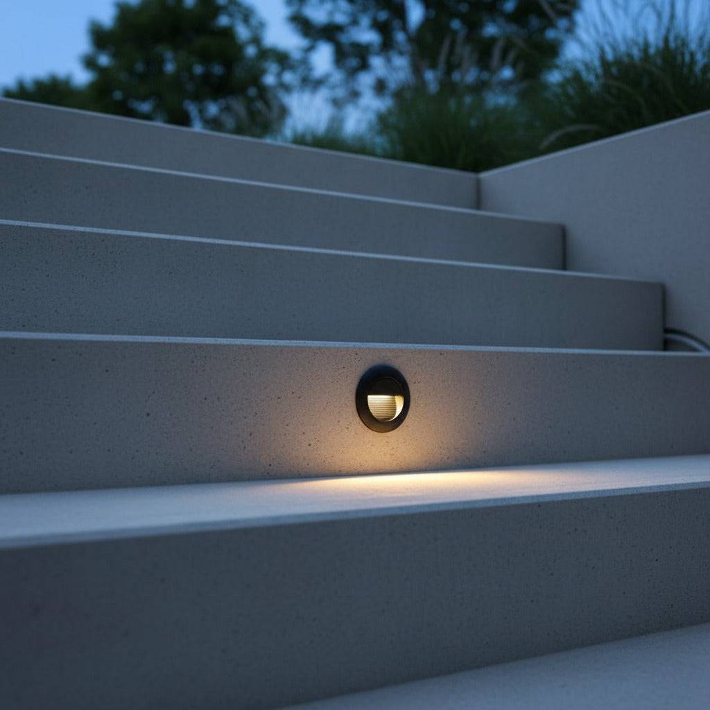 black outdoor stair light mounted in the stair riser of outdoor concrete steps 