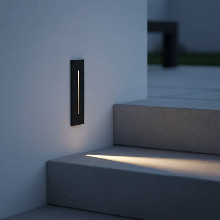 black flush mount exterior wall light mounted on wall at low level next to an outdoor concrete staircase