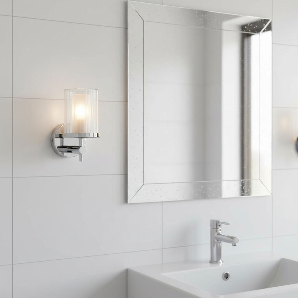 polished chrome bathroom wall light installed next to a bathroom mirror 