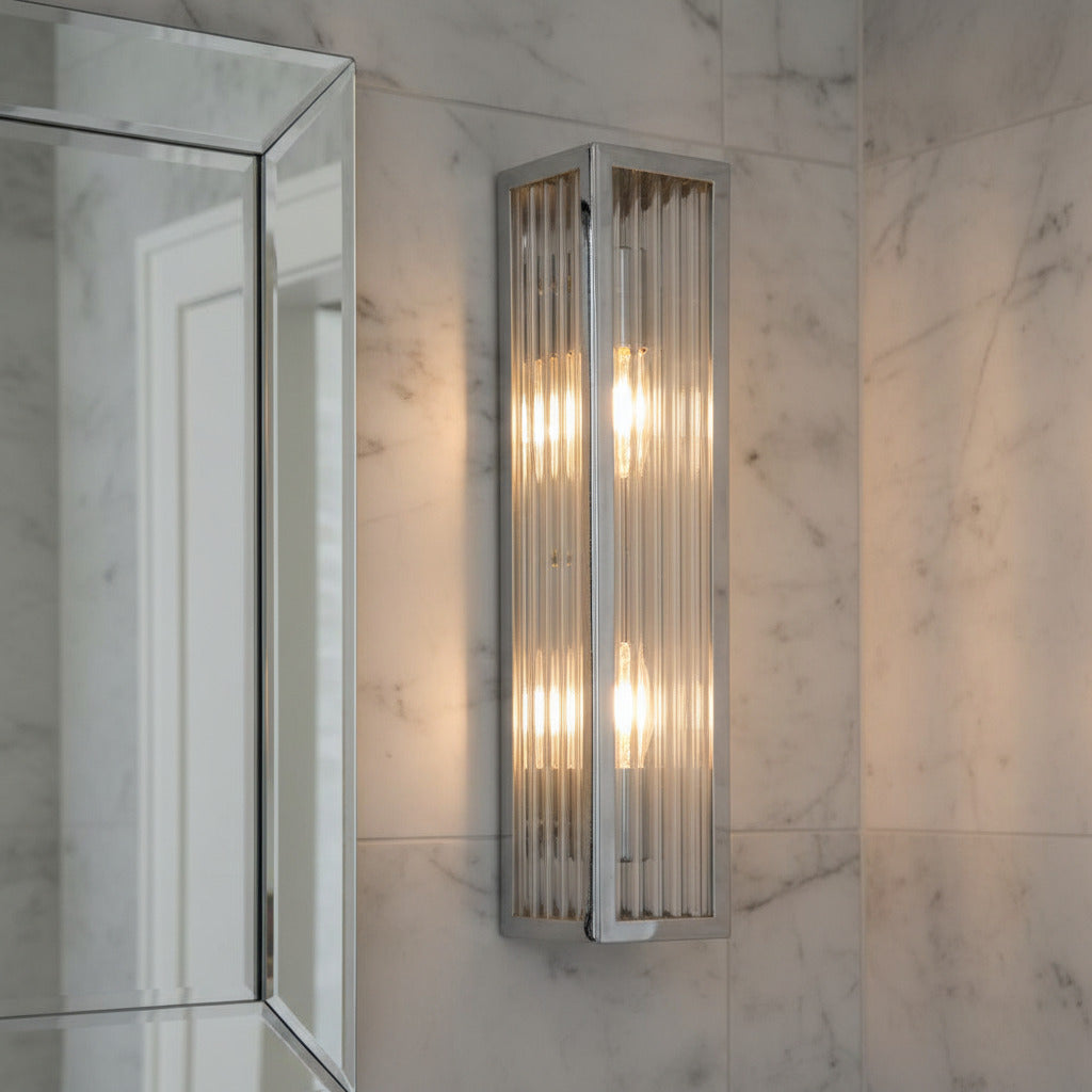 chrome bathroom anity wall light installed on a marble bathroom wall 