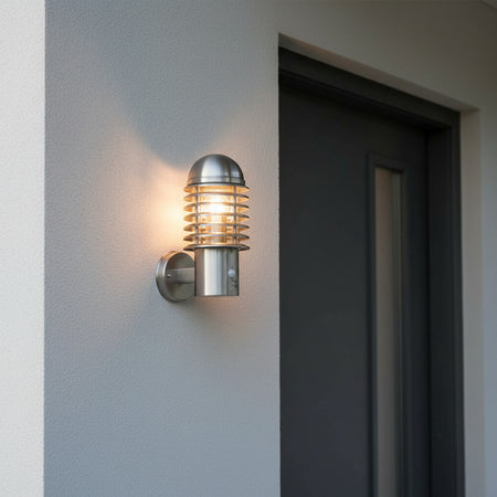 stainless steel PIR sensor outside wall light installed next to the front door of a modern home 