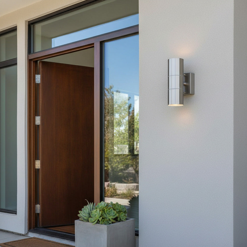 stainless steel external up down light mounted next to the front door of a house