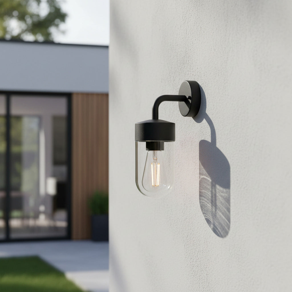 black lantern outside light installed on a concrete wall outside a house