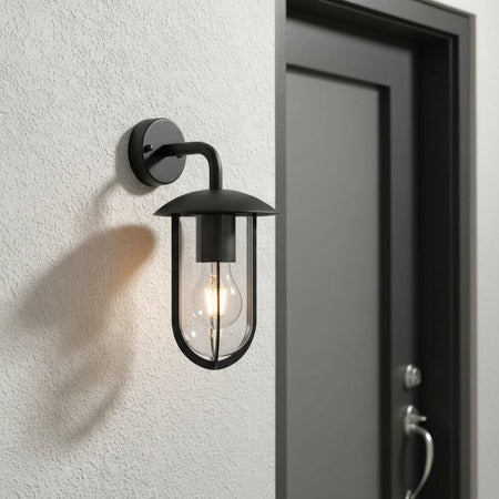 black external lantern wall light mounted on the wall next to an entrance door