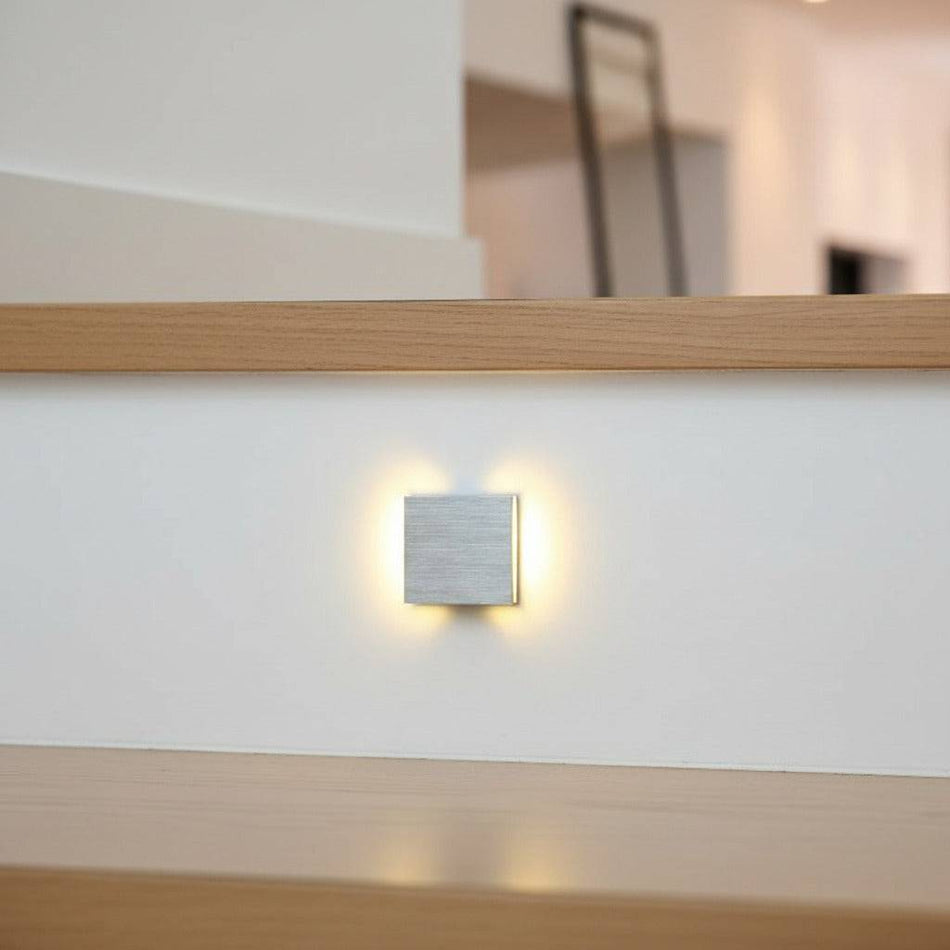 silver interior stair light mounted in the white riser of a staircase