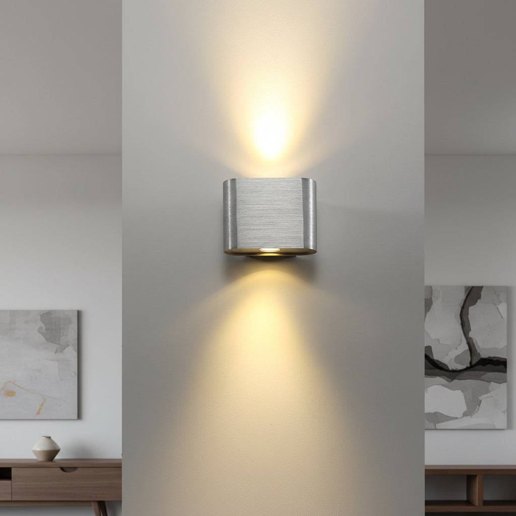 Silver finish up down indoor wall sconce on  grey wall between two rooms