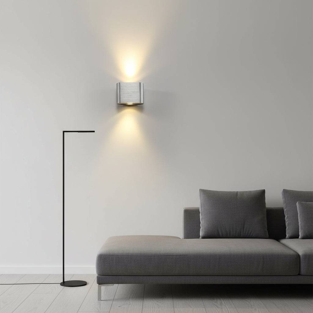 Silver metal up down indoor wall sconce above a sofa in  a modern home