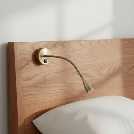 antique flexible bedside reading light fitted to a wood bed headboard