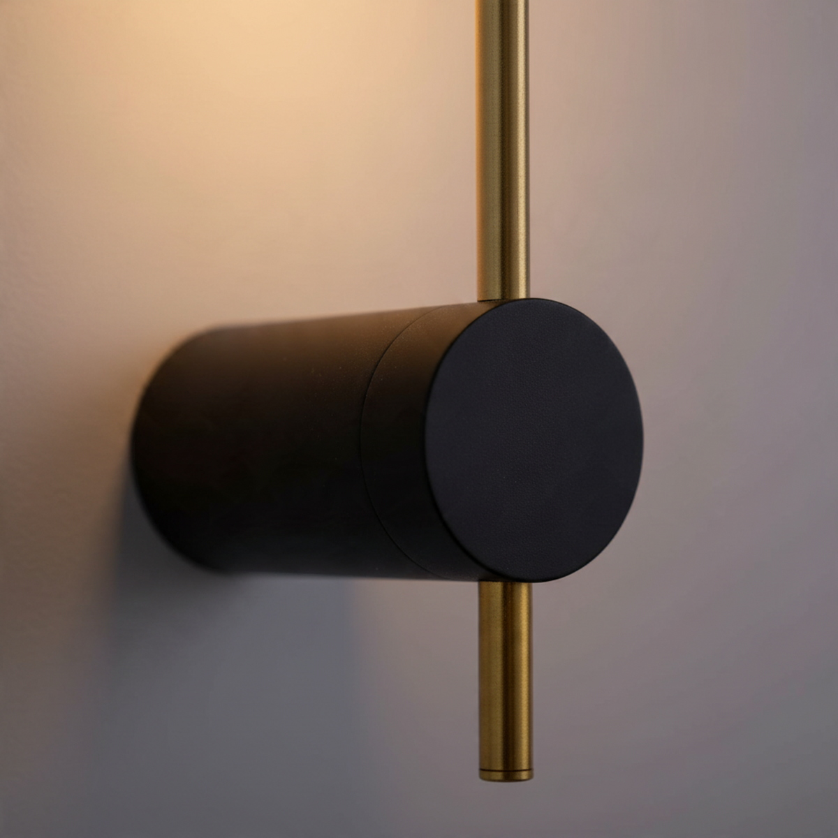 Ultra Beam Lighting Ltd 6W LED wall sconce in black and gold with a cylindrical base and warm backlit illumination.