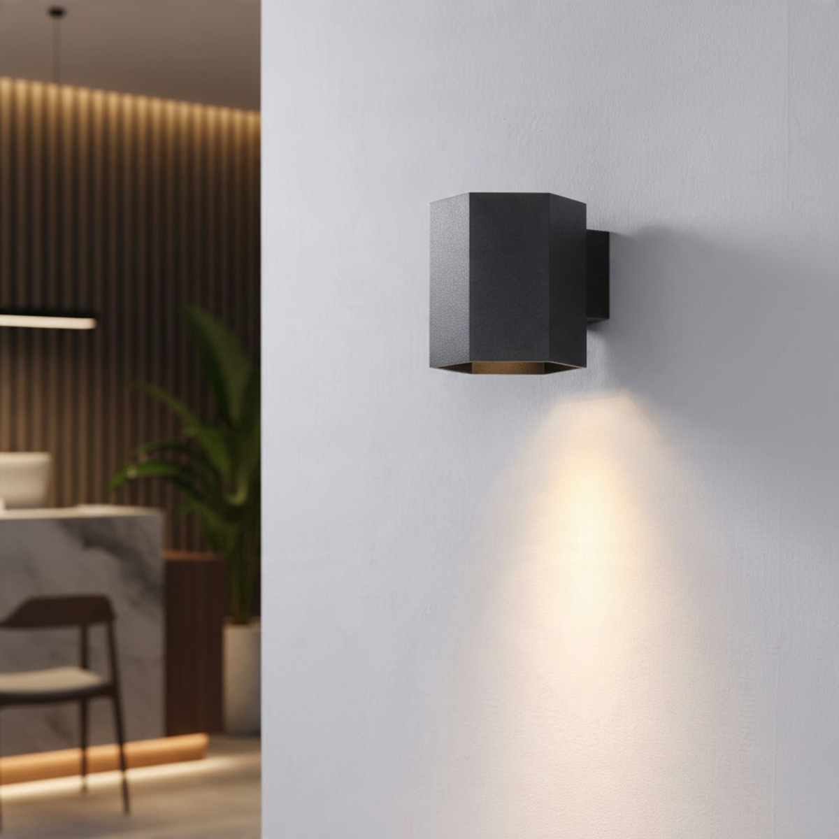 Ultra Beam Lighting Ltd black hexagonal LED wall down light casting a warm 3000K beam on a white interior wall