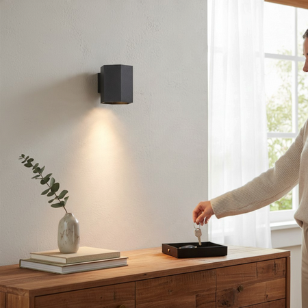 Ultra Beam Lighting Ltd black hexagonal LED wall down light casting a warm 3000K beam on a white interior wall.