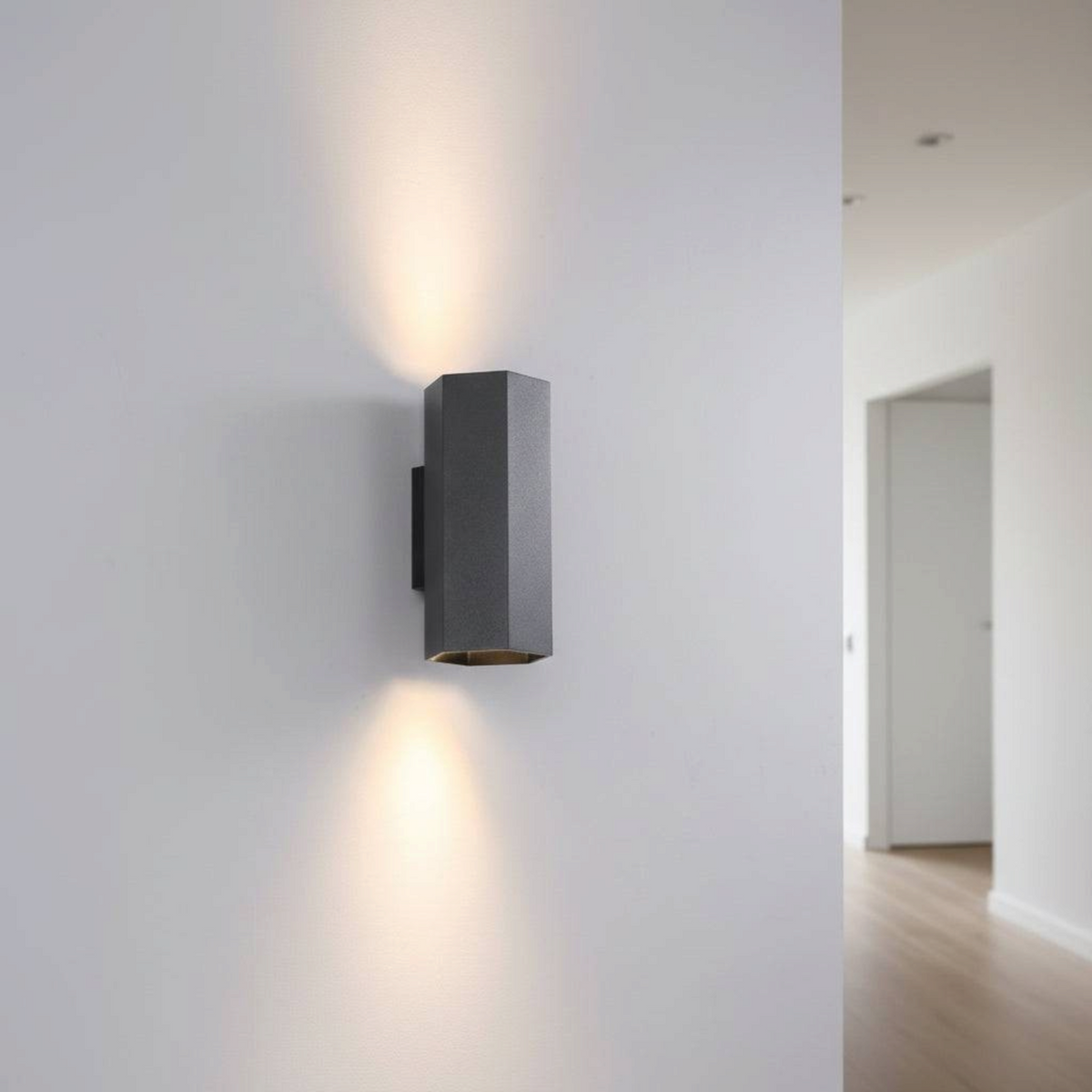 Ultra Beam Lighting Ltd black hexagonal up and down indoor wall light casting warm light on a white interior wall