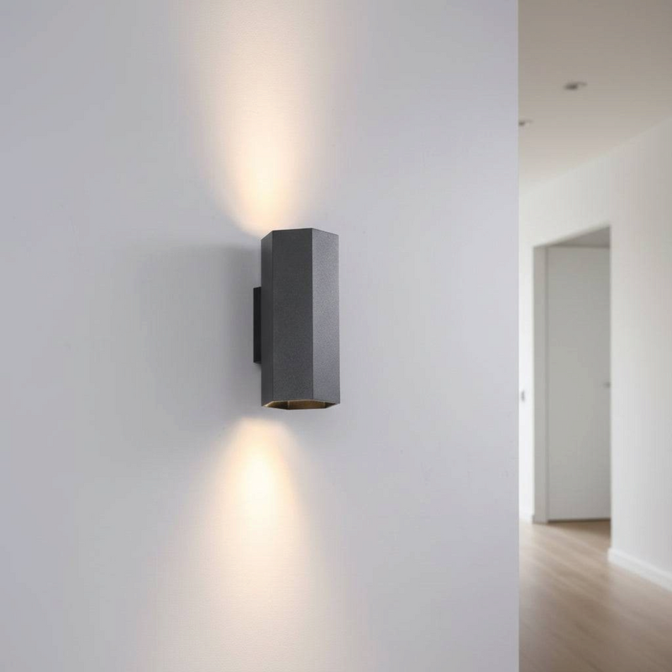 Ultra Beam Lighting Ltd black hexagonal up and down indoor wall light casting warm light on a white interior wall