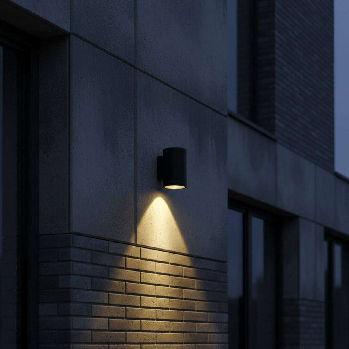 Ultra Beam Lighting Ltd 12W LED black outdoor wall downlight casting a warm downward beam on a modern brick wall