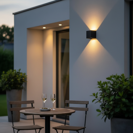 Ultra Beam Lighting Ltd black square LED up and down outdoor wall light mounted on a modern patio wall at dusk