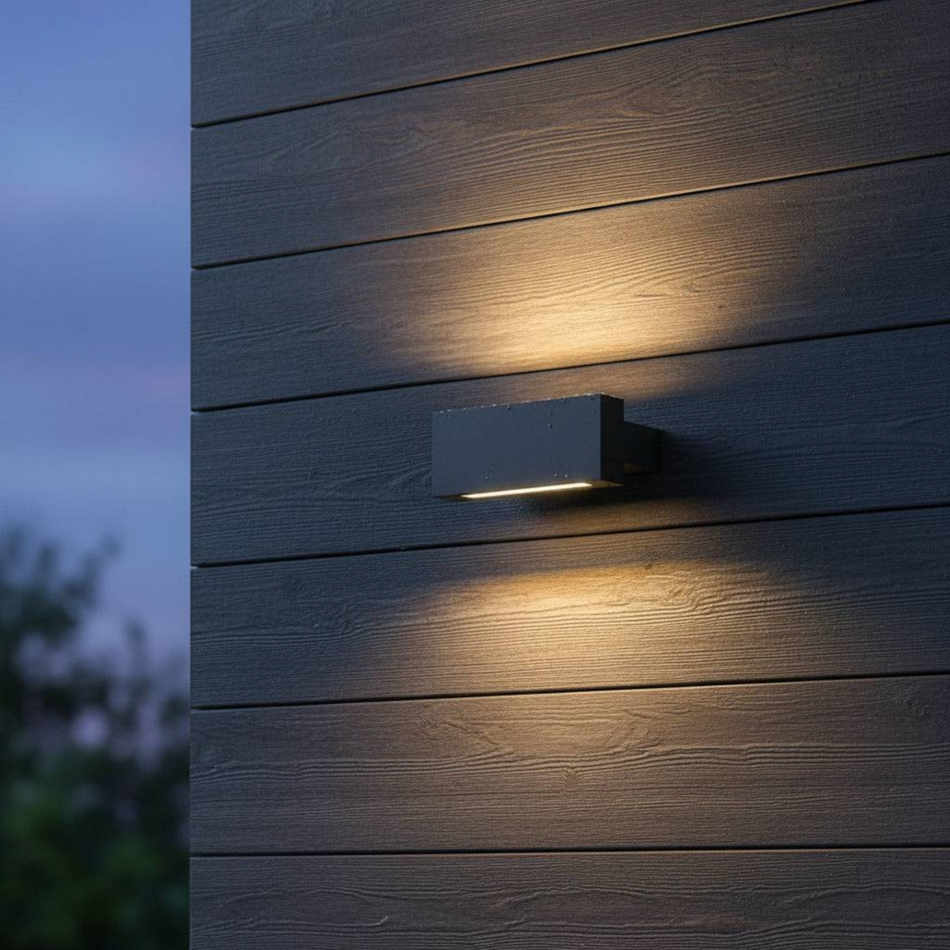 Ultra Beam Lighting Ltd rectangular black LED wall light casting warm white up and down beams on a dark wood wall.