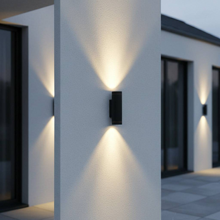 Ultra Beam Lighting Ltd black aluminium LED up and down outdoor wall light casting warm beams on a modern white wall.