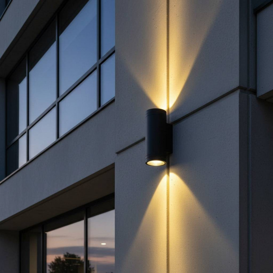 Ultra Beam Lighting Ltd 24W black LED outdoor wall light casting a dual beam on a modern building exterior