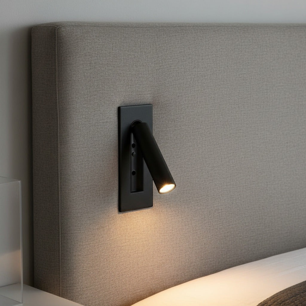black recessed adjustable LED reading wall light mounted on a fabric bed headboard