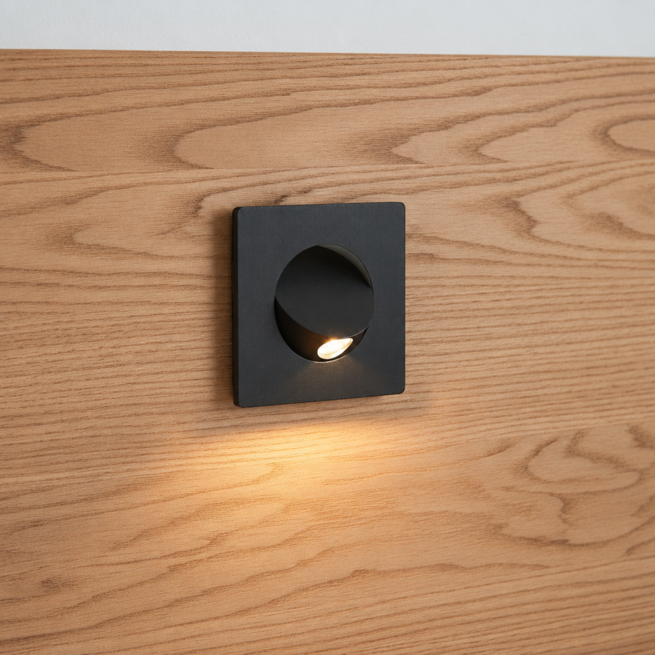 Ultra Beam Lighting Ltd square black recessed LED reading lamp tilted open on a wooden headboard