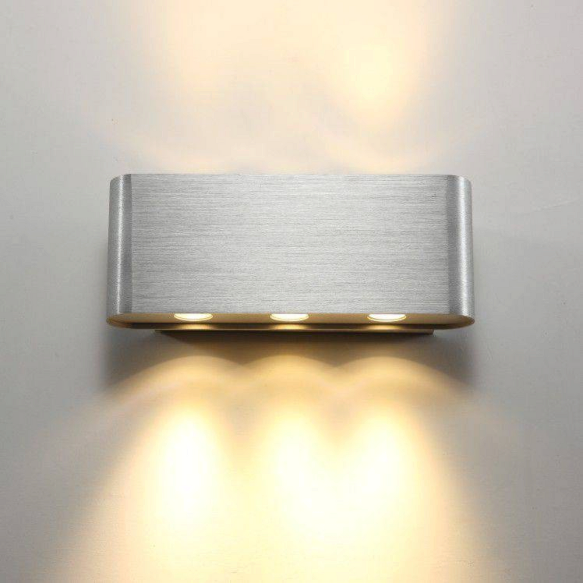 Ultra Beam Lighting Ltd brushed aluminium wall light with six LEDs casting warm up and down light beams on a wall
