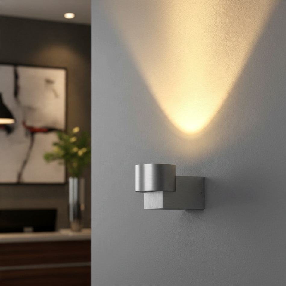Ultra Beam Lighting Ltd 5W brushed aluminium LED wall uplight casting a warm upward glow on a grey interior wall.