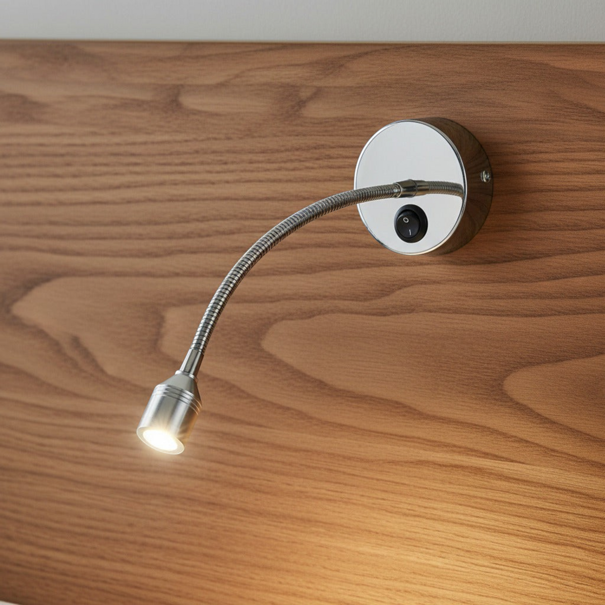 polished chrome flexible reading light mounted on a wood headboard
