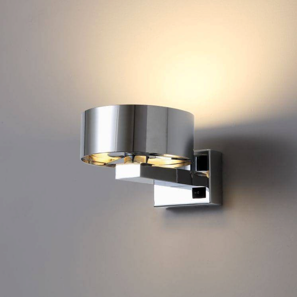 Ultra Beam Lighting Ltd 6W chrome LED bedside wall reading light with a modern cylindrical design and warm glow.