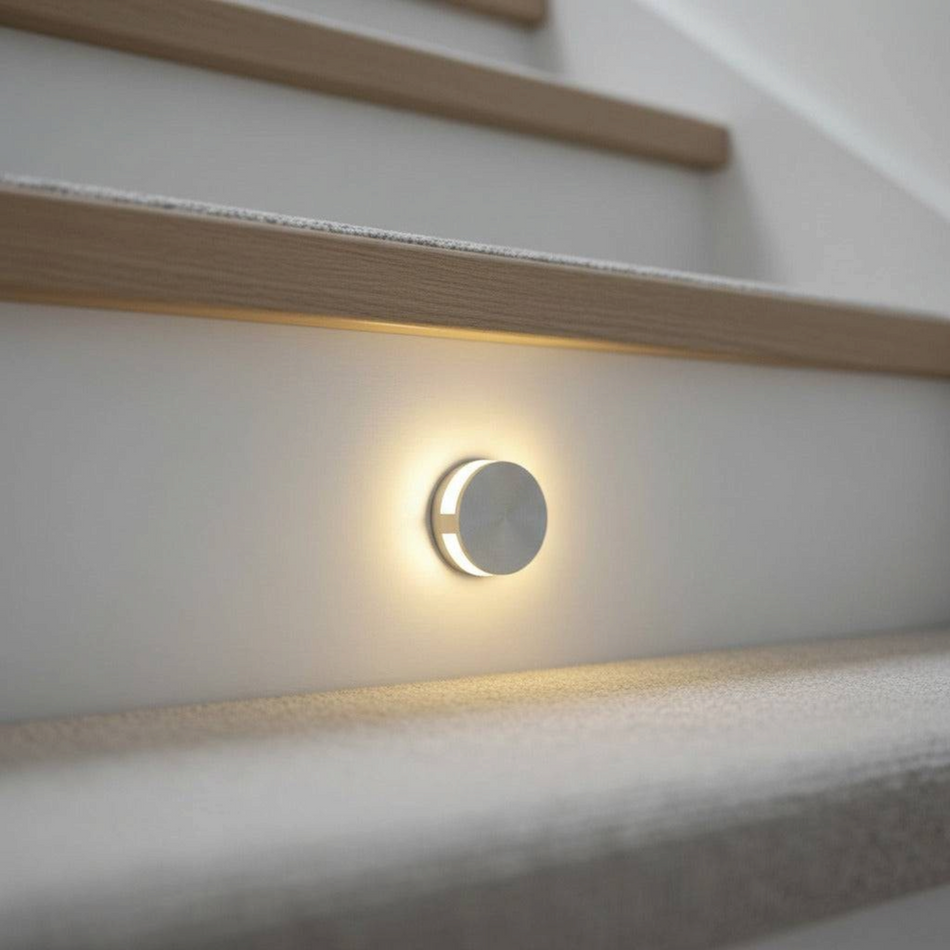 Ultra Beam Lighting Ltd Halo round 1-watt recessed LED step light in brushed aluminum installed on a staircase wall.