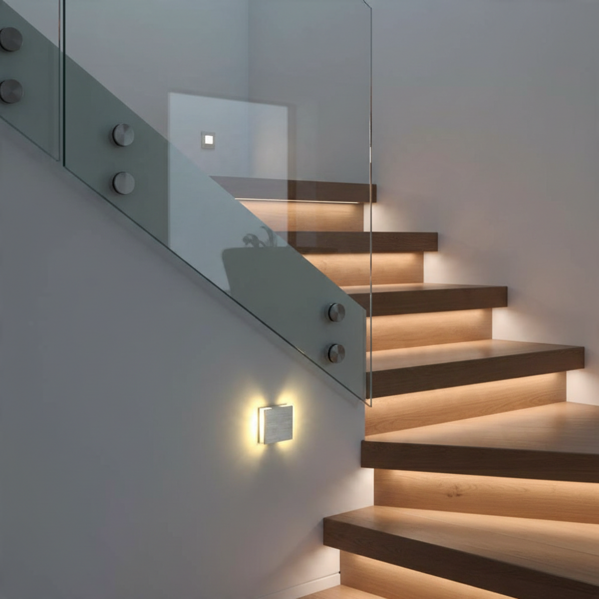 Ultra Beam Lighting Ltd Halo square brushed aluminum LED recessed stair light illuminating a modern wooden staircase.