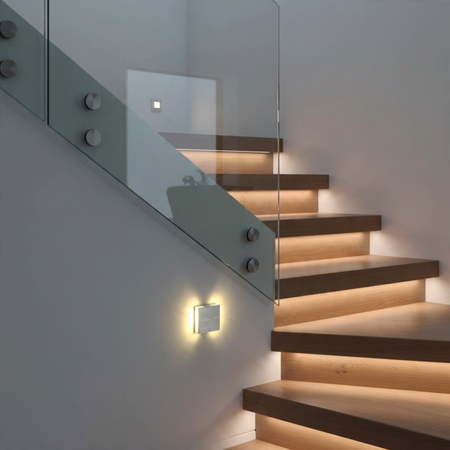 Ultra Beam Lighting Ltd Halo square brushed aluminum LED recessed stair light illuminating a modern wooden staircase.
