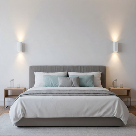 Ultra Beam Lighting Ltd white hexagonal up and down LED wall lights installed in a modern bedroom above bedside tables