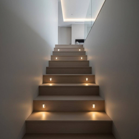 Ultra Beam Lighting Ltd round 1 watt recessed LED step lights installed on a modern wooden staircase interior